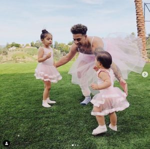 Austin McBroom wearing a girl fork, enjoying with his two daughter