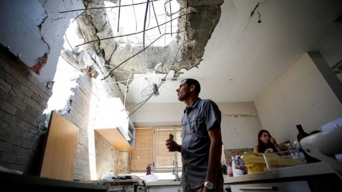 An Israeli man inspecting his house destroyed by Hamas rockets
