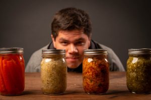 man looking at jars on wooden table