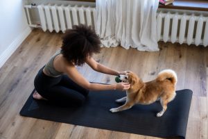 dog and girl doing yoga on mat