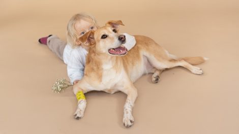 blonde boy leaning on dog