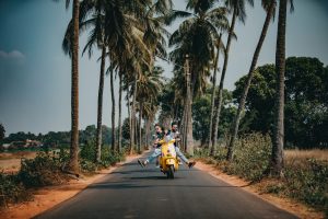 a road with a scooter having a man and woman