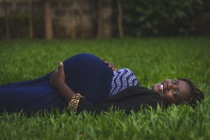 pregnant black woman lying down on grass
